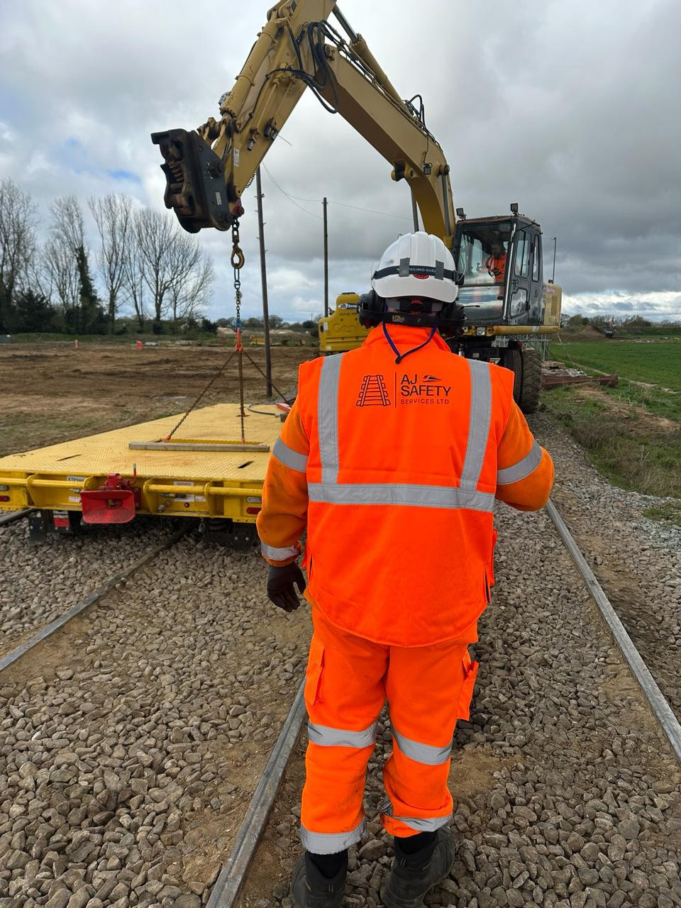 AJ Safety Services worker supervising a controlled lifting activity beside the track