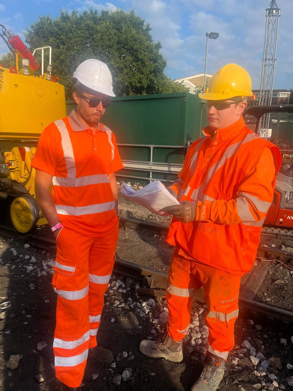 Two rail workers checking documentation together on site