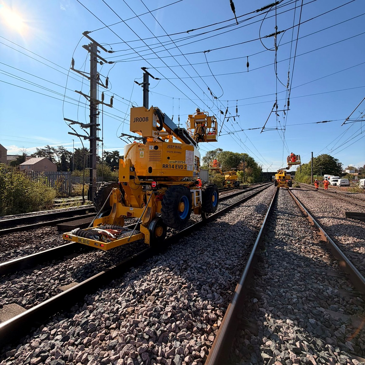 Rail access platform positioned beneath mainline overhead equipment