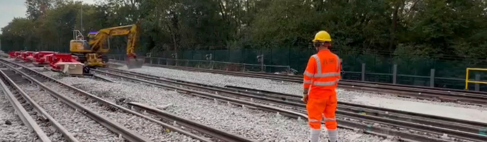 UK rail worksite with track, plant and a safety-critical worker