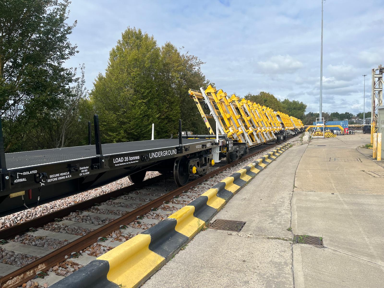 London Underground engineering train with yellow track-panel transport equipment